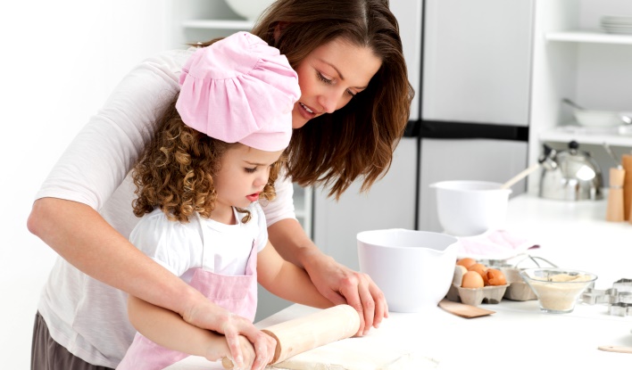 Mother and daughter using a rolling pin together