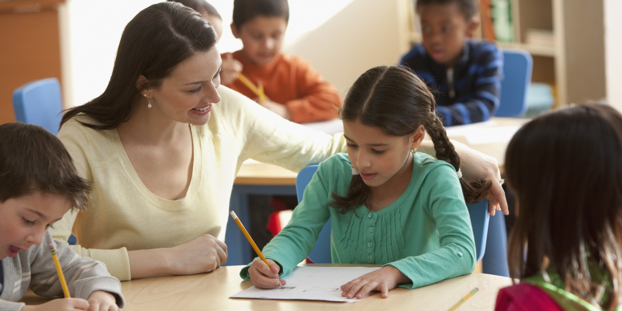 Teacher helping students in classroom